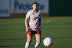 A female IU Kokomo soccer player kicks a ball on the field.